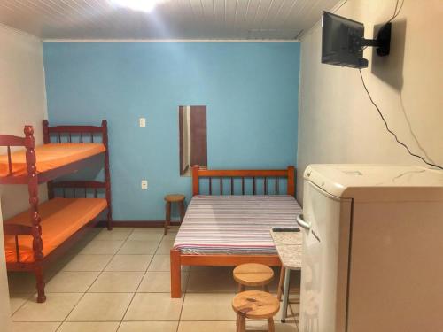 a room with a bed and a bunk bed and a table at Pousada Praia do Barco in Capão da Canoa