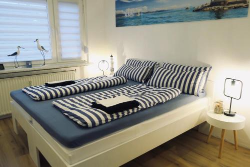 a bed with striped pillows on it in a room at FeWo Oskar - exklusive Ferienwohnung in Sarnow