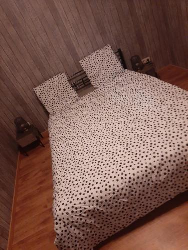 a bed with a black and white comforter at ESCALE DU BOURLINGUEUR in Charleroi