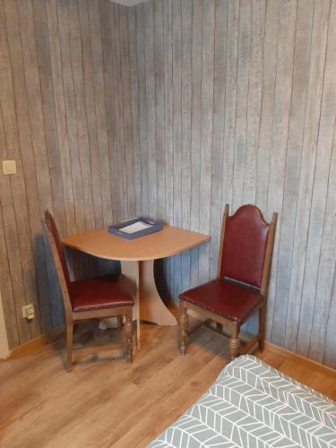 een tafel met twee stoelen en een boek erop bij ESCALE DU BOURLINGUEUR in Charleroi