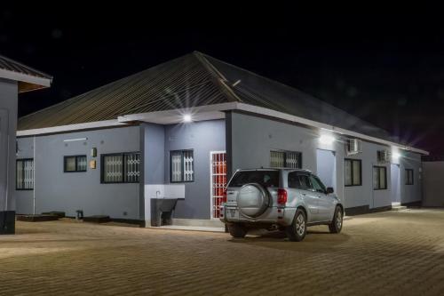 a car parked in front of a building at night at Greyville Apartments in Lusaka