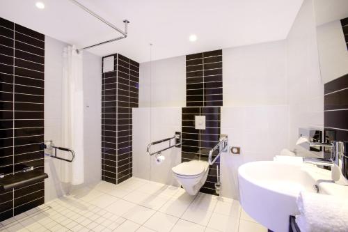a bathroom with a toilet and a sink at Holiday Inn Express Neunkirchen by IHG in Neunkirchen