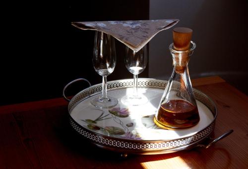 a tray with two glasses and a bottle of alcohol at Schloss Hotel Dresden Pillnitz in Dresden