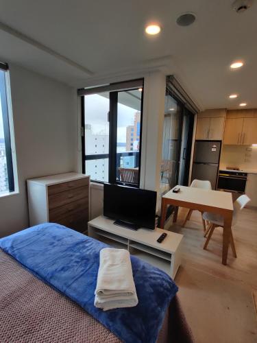 a bedroom with a bed and a desk with a laptop at Central location of Auckland Central in Auckland