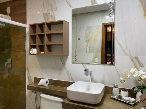 uma casa de banho com um lavatório, um WC e um espelho. em Hotel Sandis em Santarém