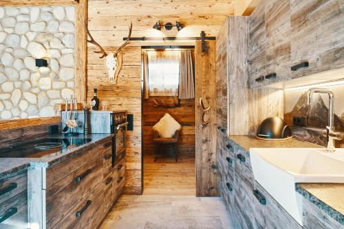 a kitchen with wooden walls and counters and a sink at Chalet Zugspitztraum in Ehrwald