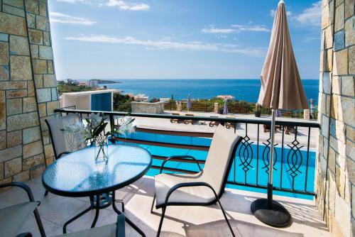 a balcony with a table and chairs and a pool at Arabela 2 Apartments in Utjeha