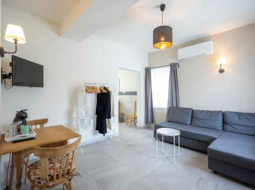 a living room with a blue couch and a table at B&B De Bloesem in Hoeselt