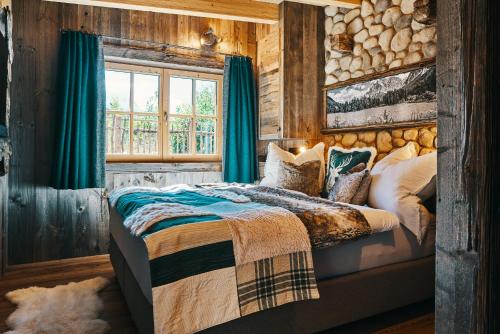 a bedroom with a bed and a log wall at Chalet Zugspitztraum in Ehrwald