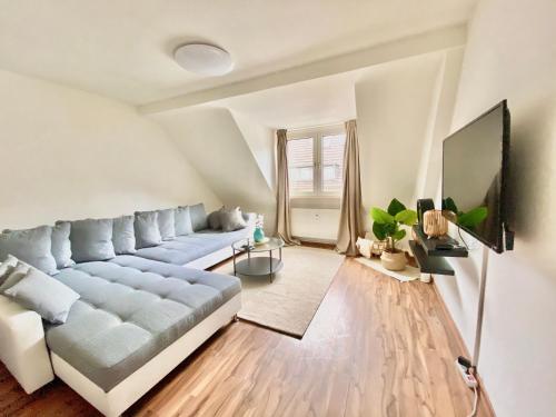 a living room with a blue couch and a tv at Ferienwohnungen im Stadtzentrum -JUNIK Apartments in Krefeld