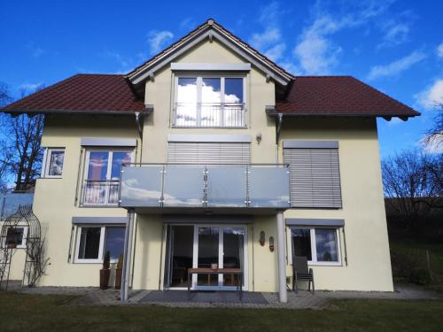 a large white house with a balcony at LandLebenLeuter in Glochen