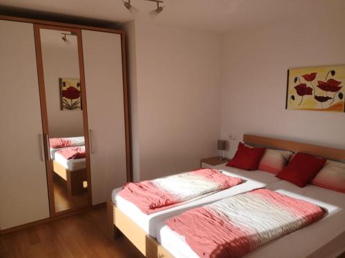 1 dormitorio con 2 camas y espejo en LandLebenLeuter, en Glochen