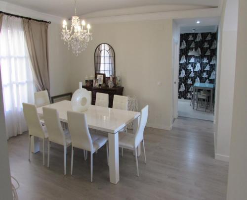 una sala da pranzo con tavolo e sedie bianchi di Apartamento a 50 metros de la playa malagueta con vistas al mar a Málaga