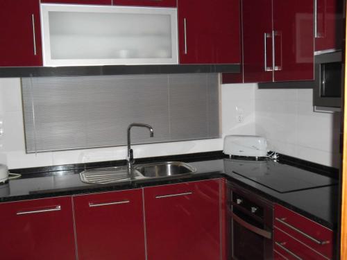 a kitchen with red cabinets and a sink at Albufeira Sea view (51) in Albufeira