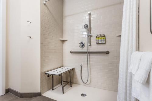 a bathroom with a shower with a stool in it at Candlewood Suites Bensalem - Philadelphia Area, an IHG Hotel in Bensalem