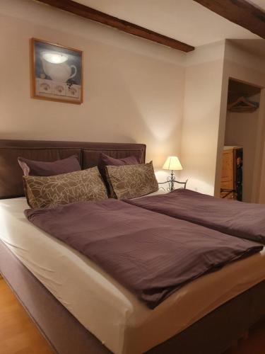 een slaapkamer met een groot bed met paarse lakens en kussens bij Café Burgstraße in Wernigerode