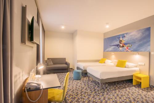 a hotel room with two beds and a couch at ibis Styles Warszawa West in Mory