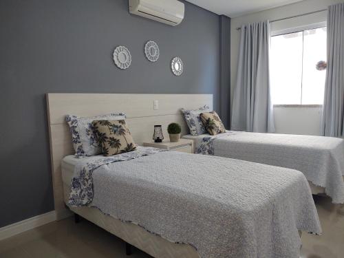 1 dormitorio con 2 camas y ventana en Apartamento Ipê Branco, Mariscal, ótima localização, en Bombinhas