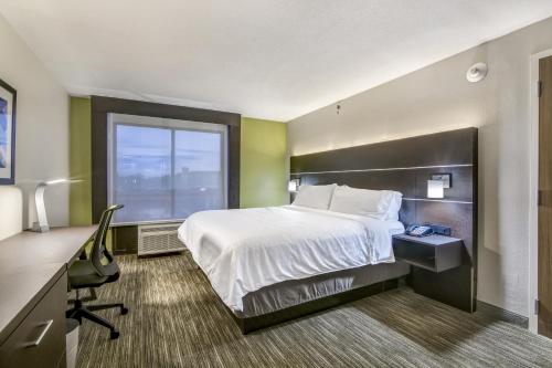 a hotel room with a bed and a desk and a window at Holiday Inn Express & Suites Longview North by IHG in Longview