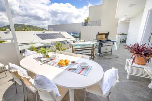 a patio with a white table and chairs and a grill at Caba Break Holiday Apartments in Cabarita Beach