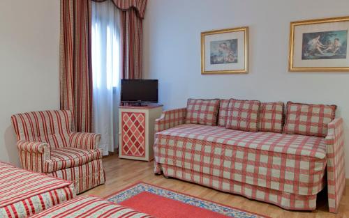 a living room with a couch and a chair at Hotel Doña María in Seville