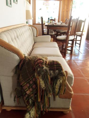 a living room with a couch with a blanket on it at La biblioteca in Olavarría