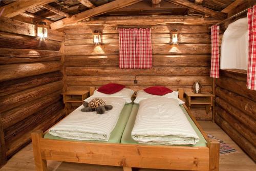 a room with two beds in a log cabin at Appartement Rossalm mit Sauna in Alpbach