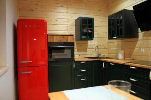 kuchnia z czerwoną lodówką i zielonymi szafkami w obiekcie Chata Zimnik, ruska bania w Szczyrku