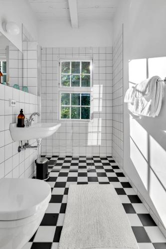 a bathroom with a black and white checkered floor at Boen Gård in Kristiansand