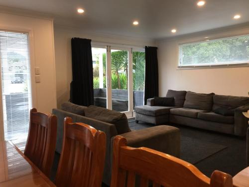 a living room with a couch and chairs at 3 & 4 Bedroom Holiday Houses Central Picton in Picton