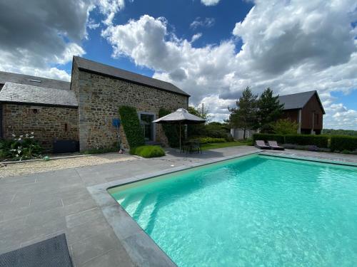 a large swimming pool in front of a house at LE REFUGE D'ELI - Le Gîte in Vitrival