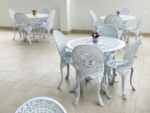 a group of white tables and chairs with flowers on them at HOTEL GRAND BOUTIQUE in Fusagasuga