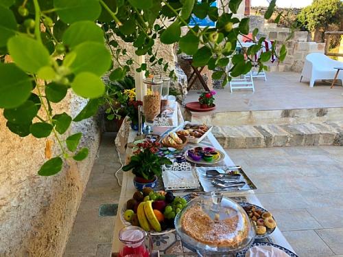 una mesa larga con comida en la parte superior en Cave Garden rooms en Favignana