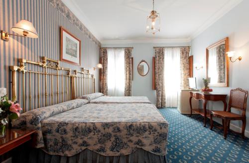 a hotel room with a bed and a desk at Hotel Doña María in Seville