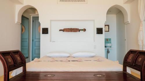 1 dormitorio con 1 cama y 2 sillas en Riad Lamp en Nanjo
