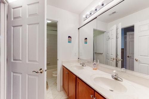 a white bathroom with a sink and a mirror at Bethany Lakes - 31292 May in Bethany Beach