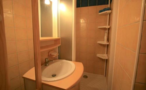 a bathroom with a sink and a shower with a mirror at Appartement - cœur de station in Enchastrayes