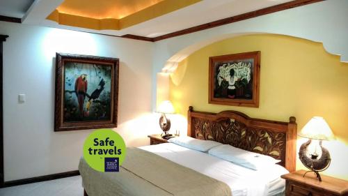 un dormitorio con una cama con un letrero que dice que viaje seguro en Suites Flamboyanes, en Mérida