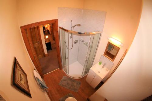 a bathroom with a shower and a mirror at Glenfiddich in Nairn