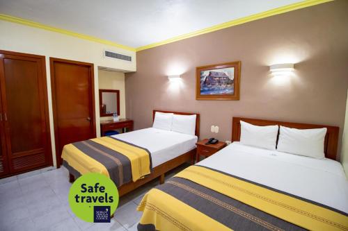 una habitación de hotel con 2 camas y un cartel que dice que viaje seguro en Hotel El Español Centro Historico en Mérida