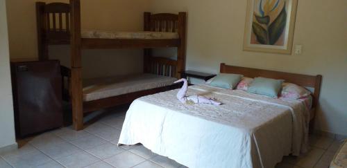 um quarto com 2 beliches e um gato numa cama em Chalé e Camping Daragona 1 em Águas de Lindoia