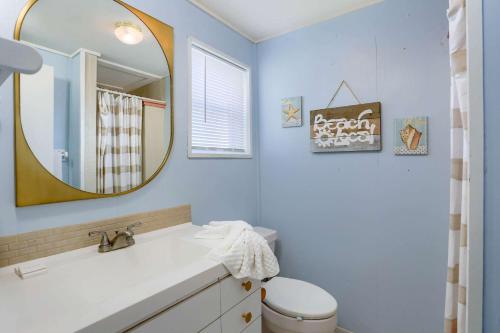 uma casa de banho com um lavatório e um espelho em Binnie’s Beachfront Bungalow em Clearwater Beach