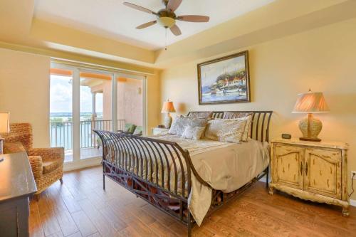 Un dormitorio con una cama con ventilador de techo y una ventana. en 801 Harborview Grande, en Clearwater Beach