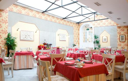 a dining room with tables and chairs with red tablecloths at Hotel Doña María in Seville