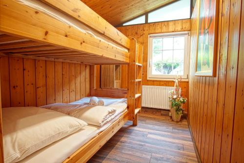 a bedroom with two bunk beds in a wooden cabin at SCHWANENNEST AM HADDORFER SEE * TOP AUSSTATTUNG in Wettringen