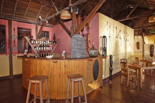a bar in a restaurant with chairs and tables at Sambatra Bed and Breakfast in Ambaro