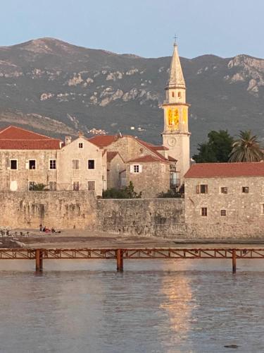 a building with a clock tower next to the water at Boutique Hotel Vissi d'Arte in Budva