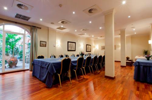 a banquet hall with blue tables and chairs at Hotel Doña María in Seville