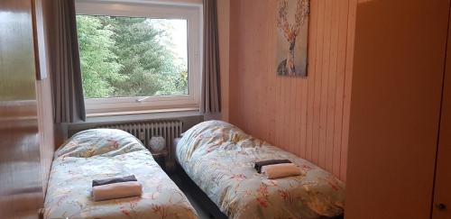 two beds in a room with a window at Appartement Nordenau in Schmallenberg