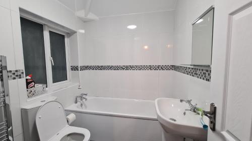 a white bathroom with a toilet and a sink at Spacious 3 Bedroom House, 6 beds in Spondon, Derby with Parking in Derby